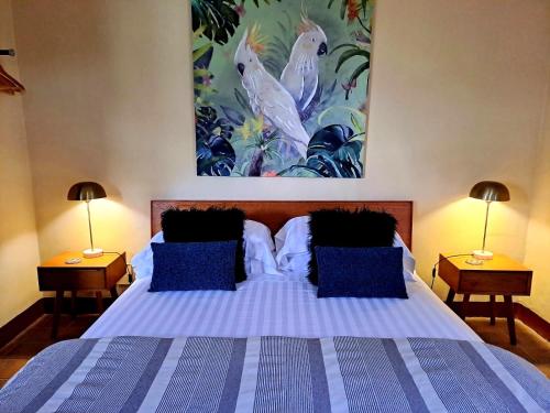 a bedroom with a large bed with blue pillows at LaChiusa Tuscany in Montefollonico