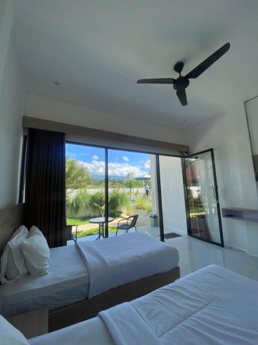 a bedroom with two beds and a view of a patio at Pondok Tetebatu Cottages and Cafe in Tetebatu