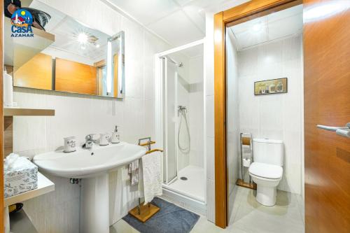 a white bathroom with a sink and a toilet at Apartamentos San Benet Casa Azahar in Alcossebre
