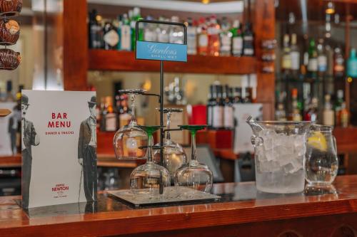 a bar with a bar menu and glasses on a counter at Muthu Newton Hotel (Near Inverness Airport) in Nairn