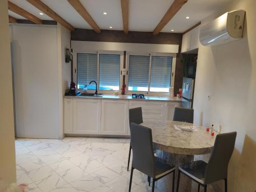 een keuken met een tafel en stoelen in een kamer bij Studio cosy avec terrasse et jacuzzi en plein air in Rians