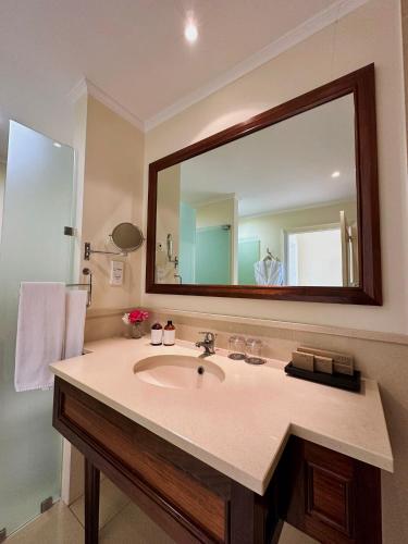 a bathroom with a sink and a large mirror at Quinta Funchal Gardens - Adults Only in Funchal
