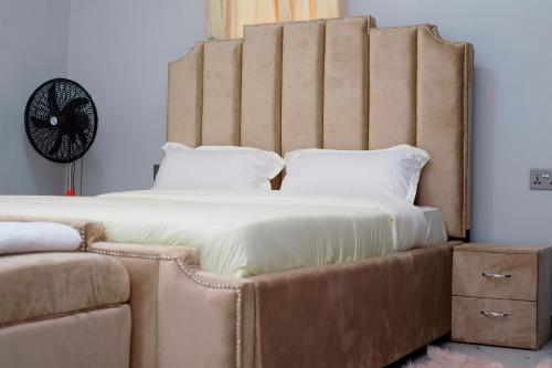 a large bed with a large headboard in a bedroom at Peacefull home Too in Kampala