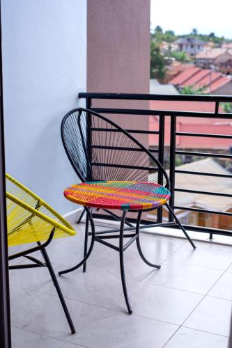a colorful chair sitting next to a table on a balcony at Peacefull home Too in Kampala