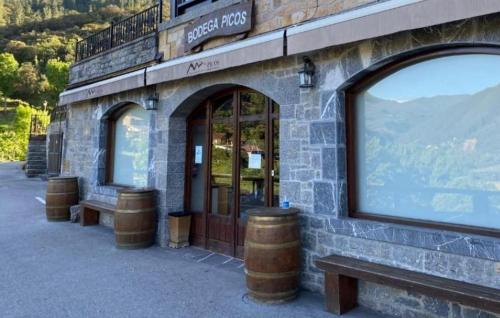 a building with two benches in front of a store at Hotel Finca Malvasia - Adults only in Cabezón de Liébana