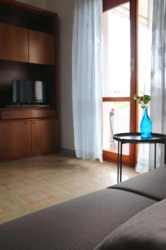 Cette chambre comprend un lit et une table avec un vase. dans l'établissement Appartamento Stella Di Mare, à Campomarino