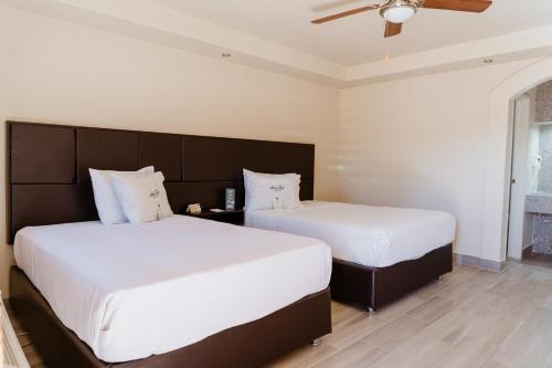 twee bedden naast elkaar in een slaapkamer bij Hotel Siesta Real in Mexicali
