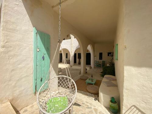 un porche con una silla y un columpio en Dar Oueghlani - Maison d'hôtes, en El Mây