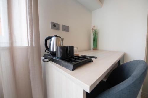 a table with a coffee maker and a kettle on it at 242 - Camera Est - Affittacamere Sara Home Chiavari, 200Metri dal Mare in Chiavari
