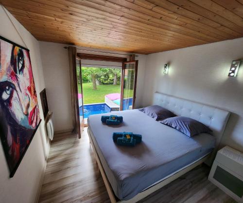 a bedroom with a bed with two bags on it at VILLA "Le Jardin" 4 étoiles - Piscine chauffée couloir 12m - Spa Balnéo Hammam - 4 Chambres dont une Love Room de 35m2 avec lit rond, vidéo projecteur Netflix, climatisation in Jardin