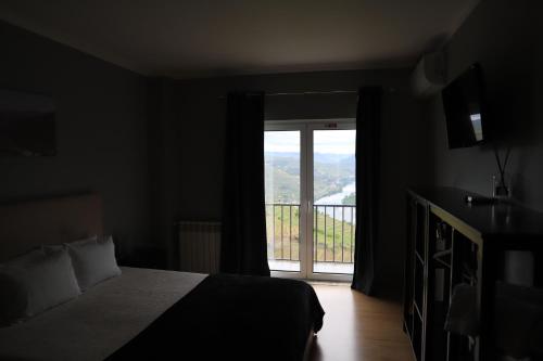 a bedroom with a bed and a window with a view at Casa Vale do Douro in Mesão Frio