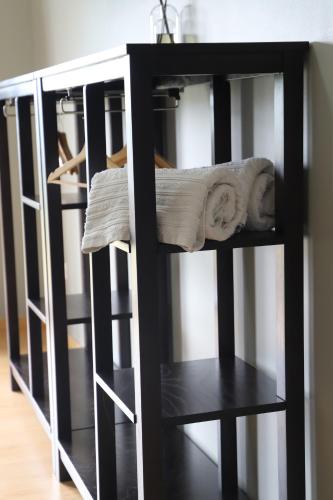 a black book shelf with folded towels on it at Casa Vale do Douro in Mesão Frio