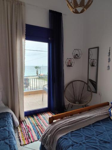 a bedroom with a bed and a view of the ocean at Mana mia Seaside Apartments in Leptokaria
