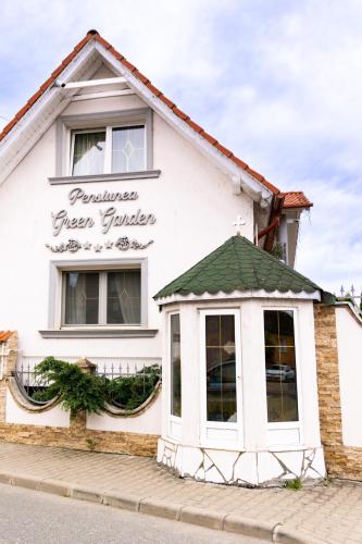 a white building with a sign on the side of it at Green Garden Avrig in Avrig