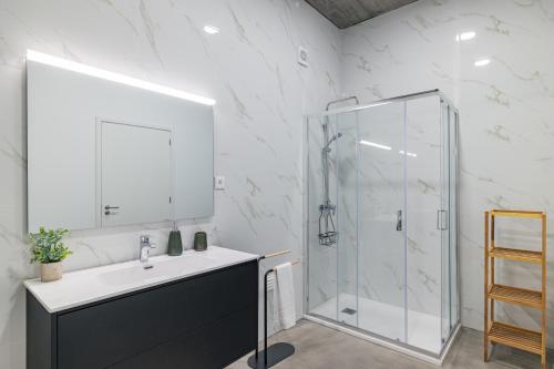 ein Badezimmer mit Waschbecken und Dusche in der Unterkunft Xª Deluxe Apartments in Ribeira Grande