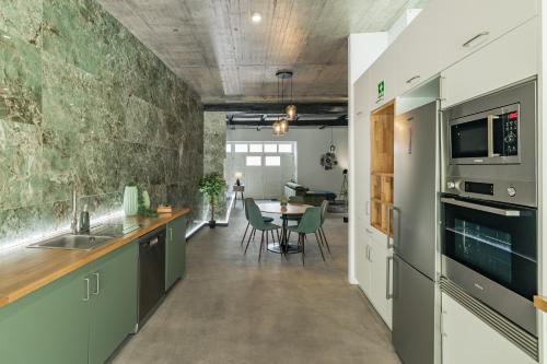 a kitchen with a table and a dining room at Xª Deluxe Apartments in Ribeira Grande