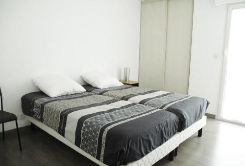 un lit avec deux oreillers dessus dans une chambre dans l'établissement Vaste et lumineux appartement, à Antibes