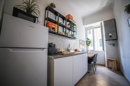 een keuken met witte kasten en een koelkast bij Cosmo GuestHouse in Rome