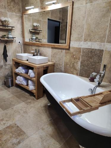 une salle de bain avec deux lavabos, une baignoire et un miroir dans l'établissement Maison provençale, à Pernes-les-Fontaines