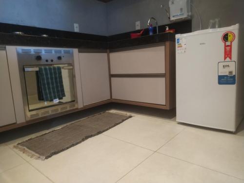 a kitchen with a stove and a refrigerator at apartamento alto padrão (centro) in Ubá
