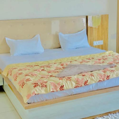 1 dormitorio con 1 cama grande y cabecero de madera en THE SILVER TULIP en Ludhiana