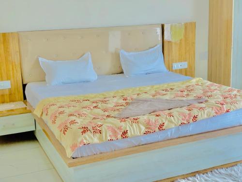 Una cama con dos almohadas y una manta. en THE SILVER TULIP en Ludhiana
