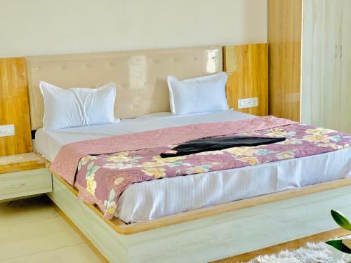 1 dormitorio con 1 cama grande y cabecero de madera en THE SILVER TULIP en Ludhiana