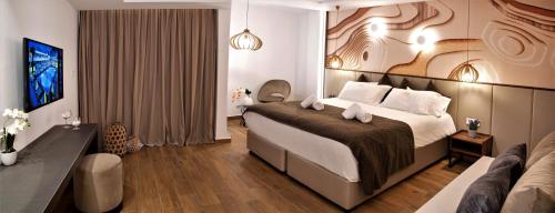 a hotel room with a large bed and a couch at Melpo Antia Hotel & Suites in Ayia Napa