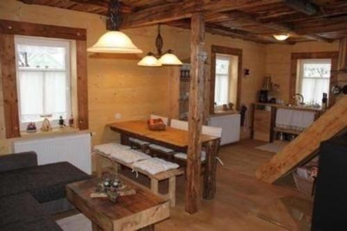 uma sala de estar com uma mesa e uma cozinha em Ferienhaus in Klingenthal mit Terrasse, Grill und Garten em Klingenthal