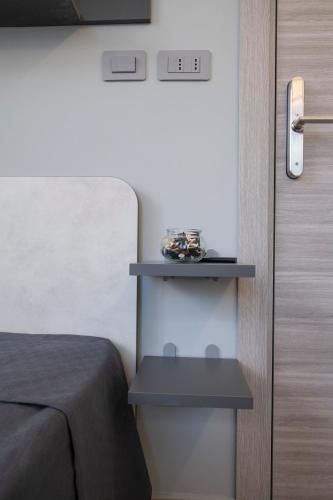 a bedroom with a bed and a shelf next to a door at 241 - Camera Nord Est - Affittacamere Sara Home Chiavari, 200Metri dal Mare in Chiavari