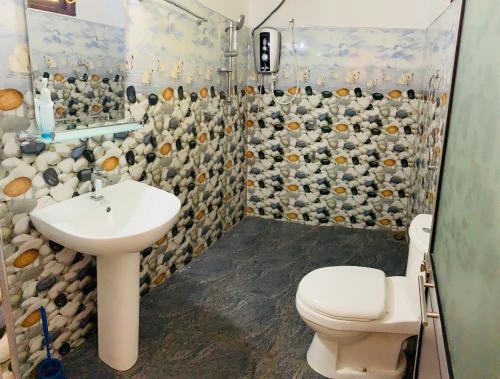 a bathroom with a sink and a toilet and a shower at Lake Wind in Habarana