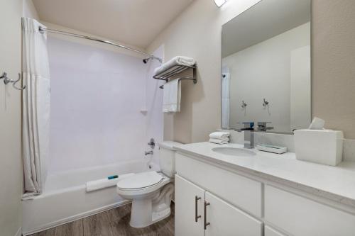 biała łazienka z toaletą i umywalką w obiekcie Soka Suites Dallas - Las Colinas w mieście Irving