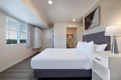 a bedroom with a large bed and a window at Soka Suites Dallas - Las Colinas in Irving