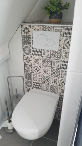 La salle de bains est pourvue de toilettes blanches et de carrelage. dans l'établissement Appartement T2 hippodrome, à Séné