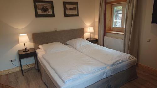 a bed in a bedroom with two lamps on tables at Lüdersburger Strasse 15e in Lüdersburg