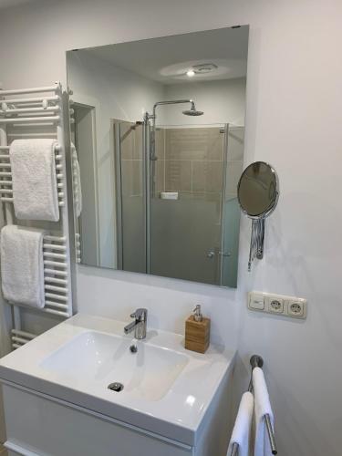 a white bathroom with a sink and a mirror at Lüdersburger Strasse 15e in Lüdersburg