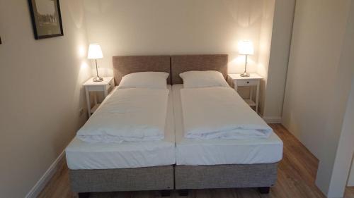 two beds in a small room with two lamps at Lüdersburger Strasse 15b in Lüdersburg