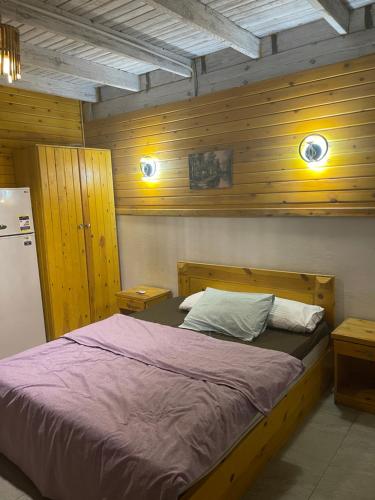 Bett in einem Zimmer mit Holzwänden in der Unterkunft Sky Dahab Hotel in Dahab