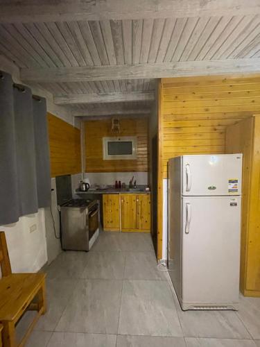 a kitchen with a white refrigerator and wooden walls at Sky Dahab Hotel in Dahab