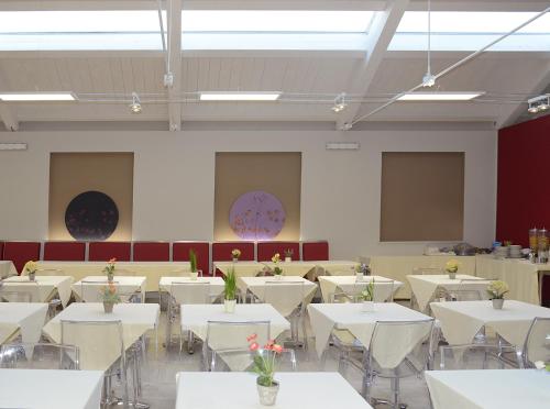 a room with white tables and flowers on them at Hotel Giotto in Turin