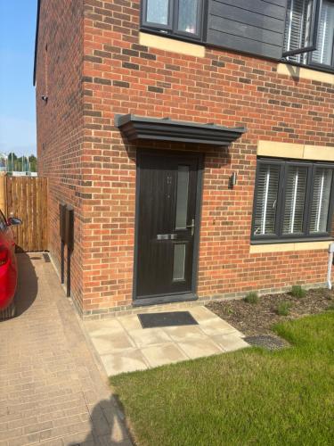 a black door on the side of a brick building at Foxglove Close in Middlesbrough