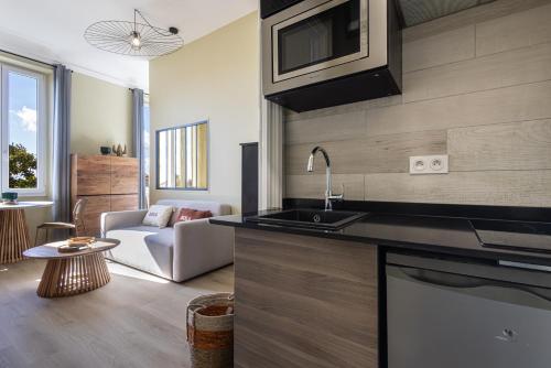 une cuisine avec un évier et un salon dans l'établissement Cocon côtier, échappée mer, à 500m de la plage, à Villeneuve-Loubet