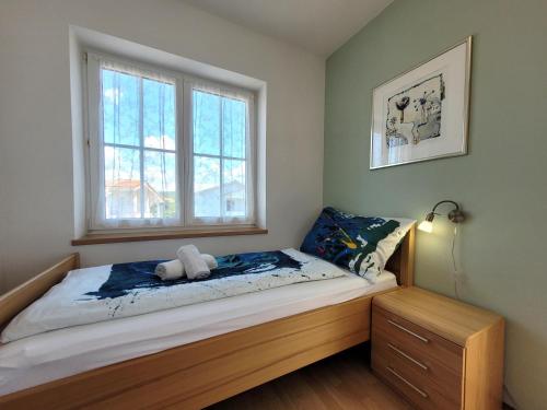 a bedroom with a bed with a teddy bear on it at Apartment Danica in Malinska