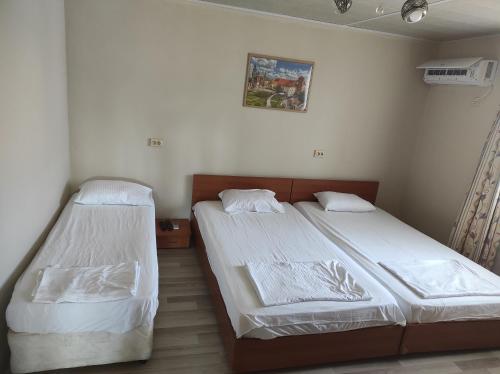 two beds in a room with white walls at Вила Никови in Durankulak