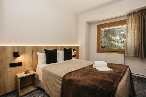 Habitación de hotel con cama grande y ventana en La Trobada Hotel Sport, en Ripoll