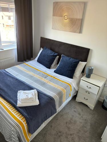 1 dormitorio con 1 cama grande con almohadas azules en Foxglove Close, en Middlesbrough