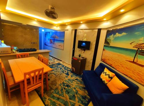 a living room with a table and a blue couch at Blue Bay Asia Sokhna Aqua Park for rent O o in Ain Sokhna
