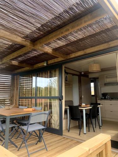 une pièce avec une table et des chaises et une cuisine dans l'établissement Le gîte de la vallée en baie, à Mons-Boubert