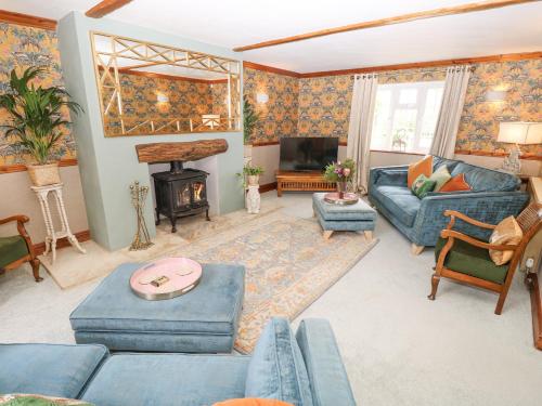 a living room with blue furniture and a fireplace at Horseshoe Cottage in Romsey