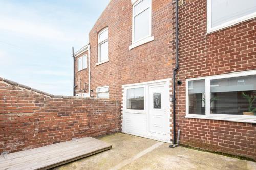 a brick building with a white door on it at Host & Stay - Milbanke House in Seaham